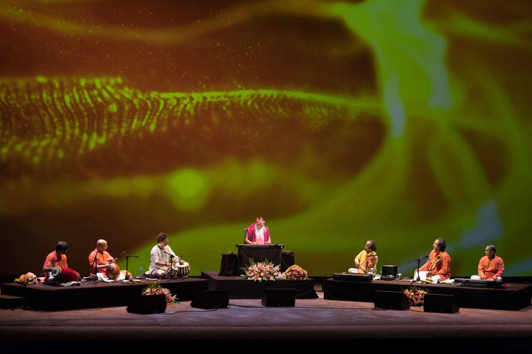 Concert — Sri Swamiji with ensemble, green nature backdrop