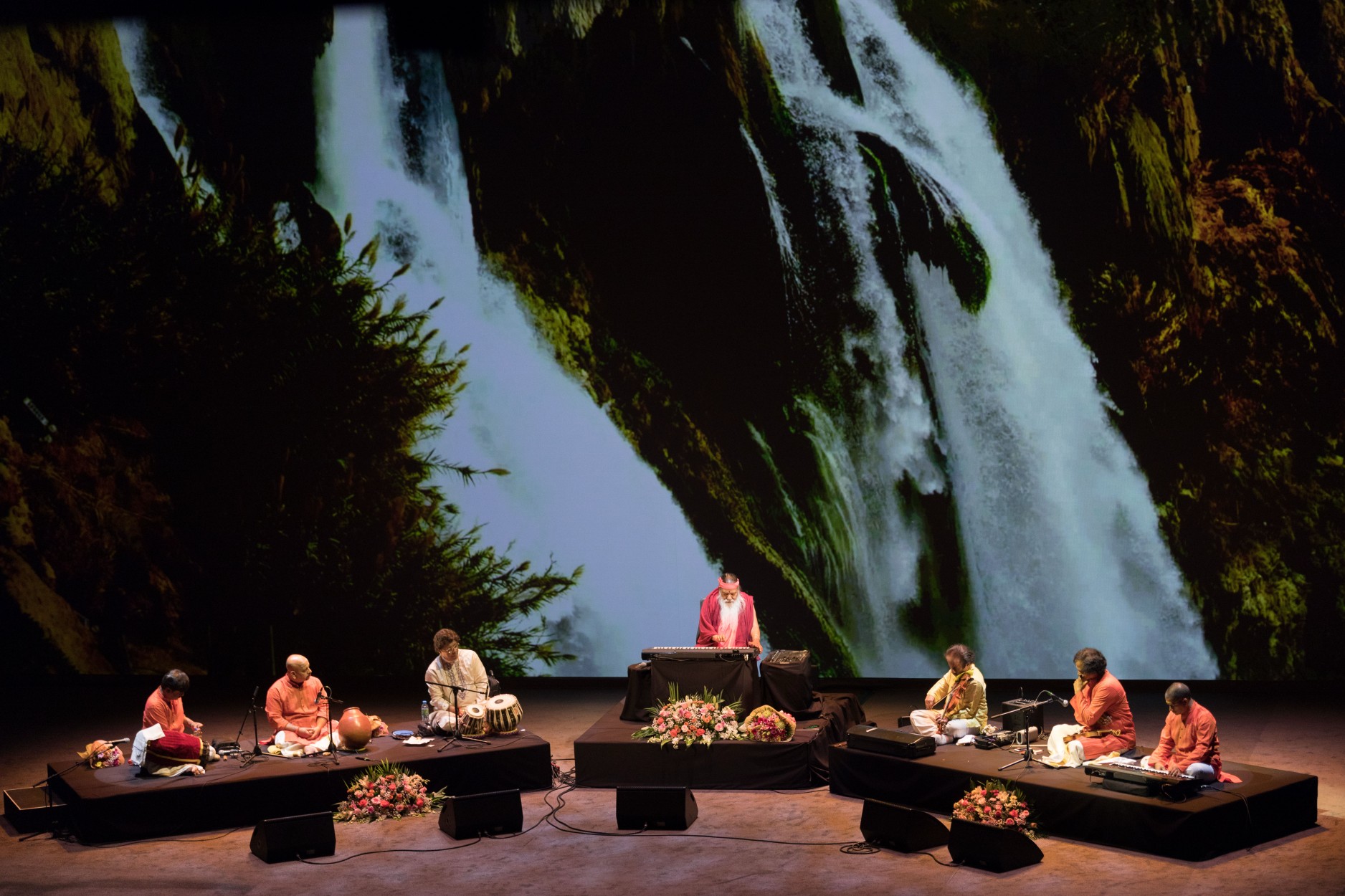 Concert — Sri Swamiji with ensemble, waterfall backdrop