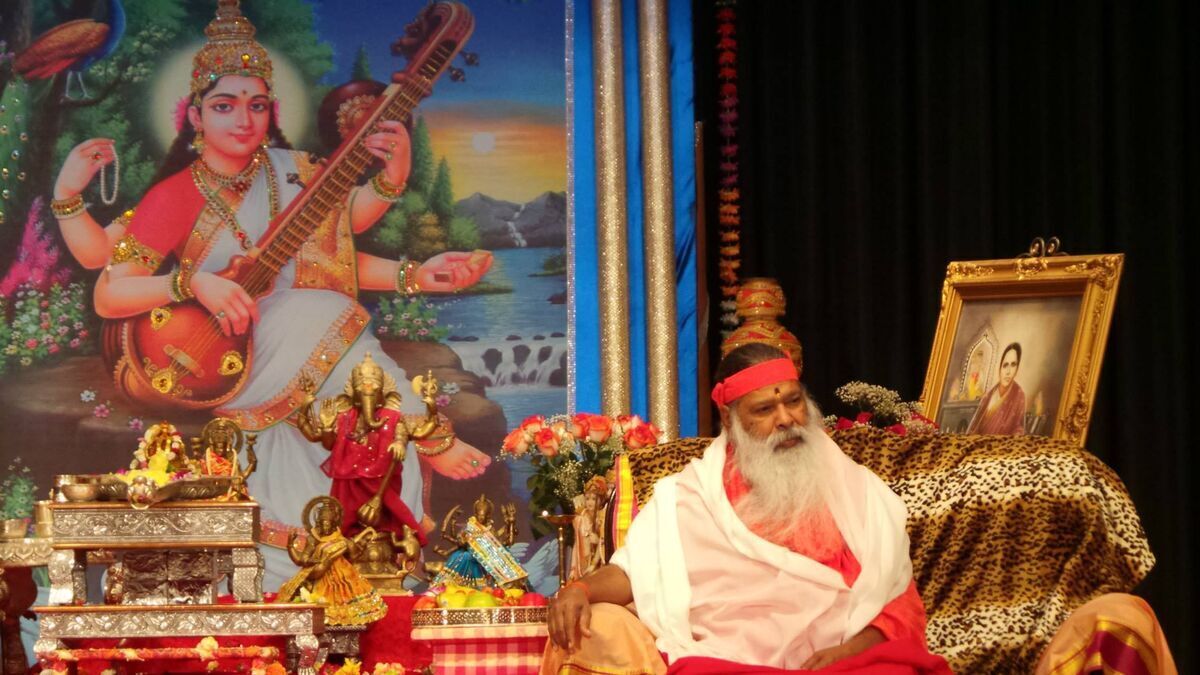 Sri Swamiji on stage — Goddess Saraswati backdrop