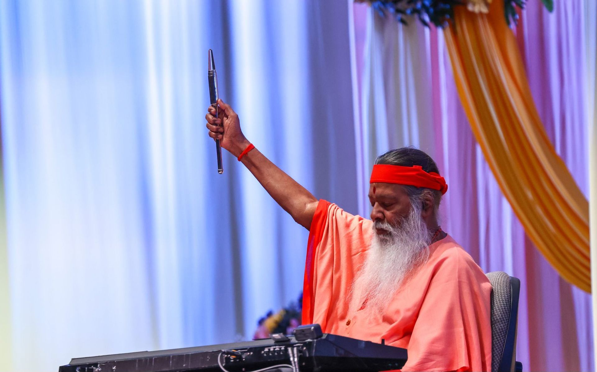 Sri Swamiji performing at synthesizer on stage